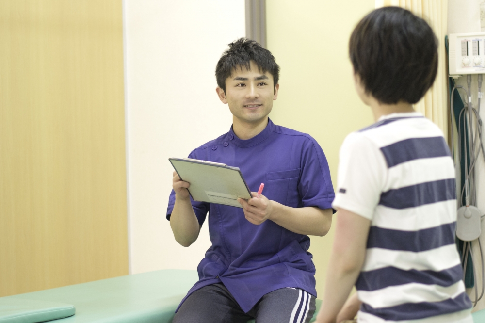 院内で患者様のお話を伺う施術者